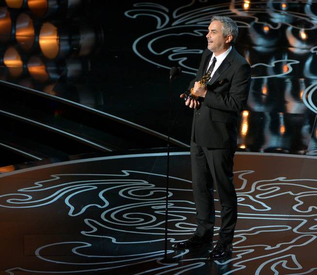 Alfonso Cuaron accepts the award for best director of the year for "Gravity" during the Oscars at the Dolby Theatre on Sunday, March 2, 2014, in Los Angeles.  (Photo by John Shearer/Invision/AP)